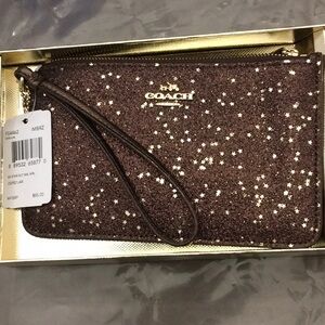 Coach brown sparkle with stars wristlet
BNWT